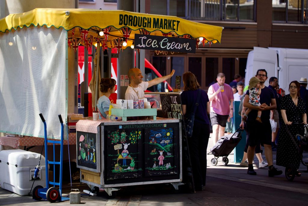 A woman is standing in front of a food cart