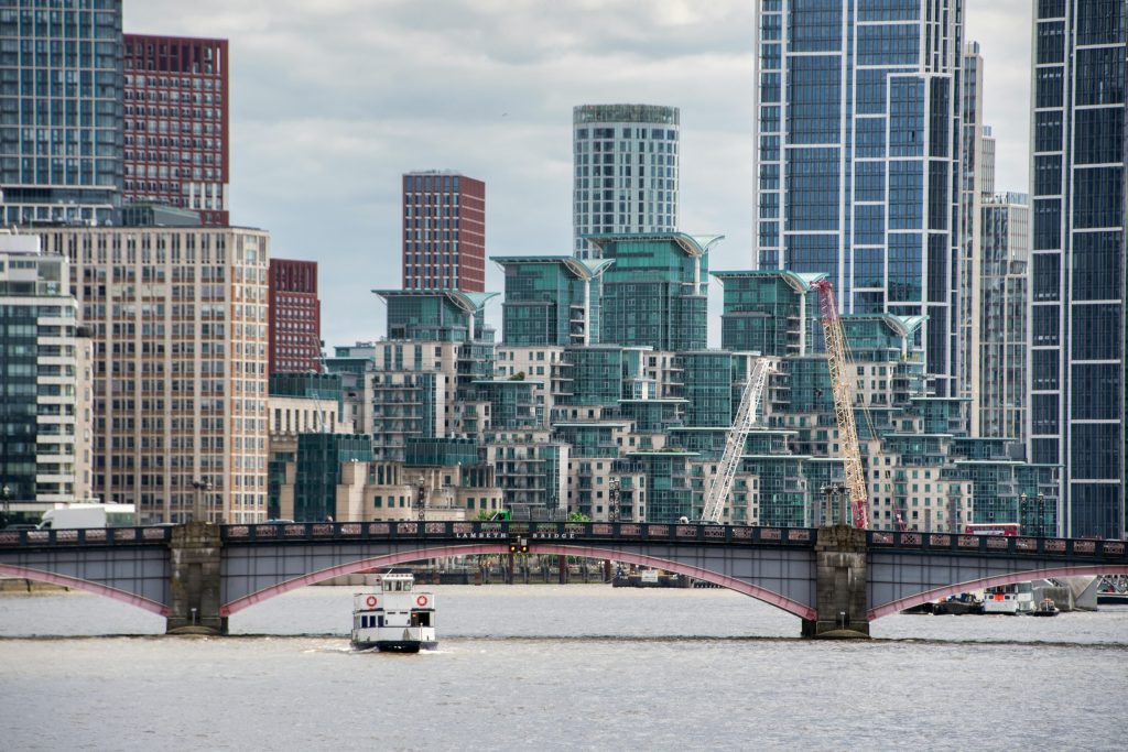A boat is crossing a river in front of tall buildings